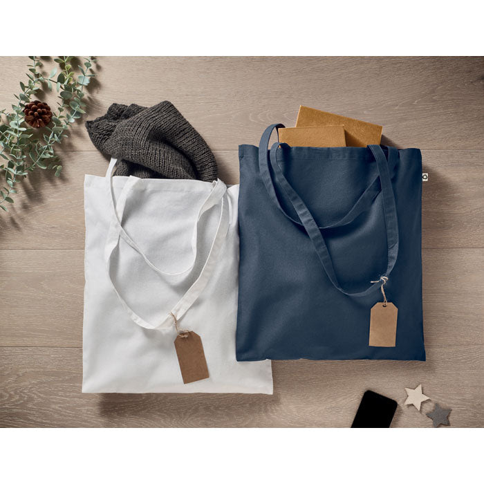 Bolsas de algodón blanca y azul marino sobre una mesa de madera